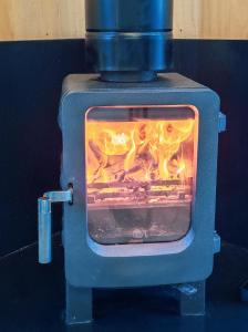 a blue stove with a fire inside of it at cozy Black Forest Tiny House close to lake in Schluchsee