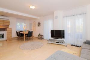 Sveti Ivan DobrinjskiにあるVilla Adelineのソファ、テレビ、テーブルのあるリビングルーム