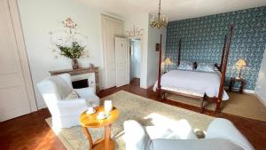 a living room with a bed and a table at Le Clos de Paris in Fresnay-sur-Sarthe