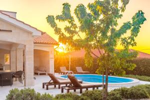 a patio with chairs and a swimming pool at Villa Adeline in Sveti Ivan Dobrinjski
