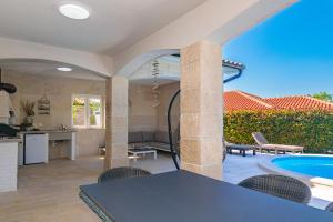 Sveti Ivan DobrinjskiにあるVilla Adelineのキッチン、リビングルーム(テーブル、スイミングプール付)