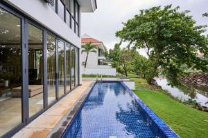 an infinity pool in the backyard of a house at Ocean Sunny Villas Da Nang in Danang
