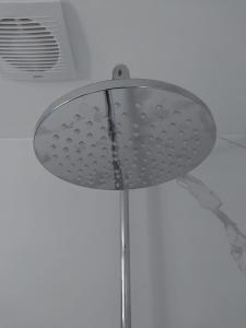 een douchekop in een badkamer met een plafond bij 't Vakansie'uus in Serooskerke +14 foto's