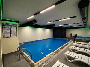 uma grande piscina num quarto com cadeiras em Sera Lake Center Hotel em Trabzon