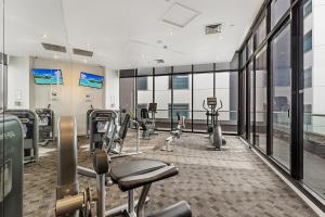 een fitnessruimte met loopbanden en cardio-apparatuur in een gebouw bij Executive Unit with Pool and Gym near Riverfront in Melbourne