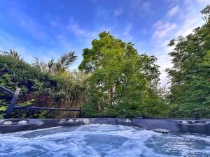 a hot tub in a garden with trees in the background at Chy Mena. South facing lodge with hot tub & views. in St. Agnes 