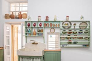 a kitchen with green cabinets and a sink and vases at CAMBANIS MΑΝSION in Mýkonos City +42 photos