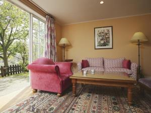 ein Wohnzimmer mit einem rosa Sofa und einem Tisch in der Unterkunft Forest Villa Huis Ten Bosch in Sasebo + 7 Fotos