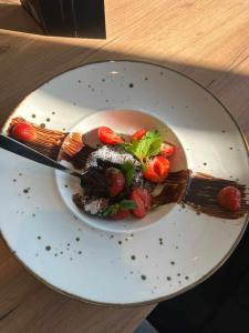 un plato con un postre con un tenedor y fresas en Mielno Hotel Boutique en Mielno