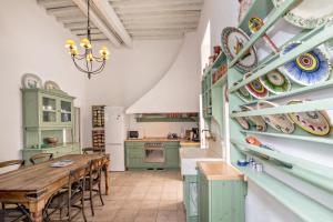 a kitchen with green cabinets and a wooden table at CAMBANIS MΑΝSION in Mýkonos City