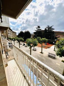 a balcony with a view of a park with benches at Apartamento en pleno centro con parking incluido ATUAIRE ZARAUTZ in Zarautz