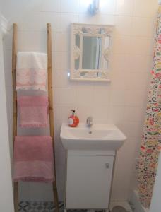 a bathroom with a sink and a mirror and towels at Alfama Shabby Chic Flat in Lisbon