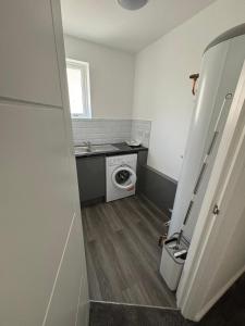 a small bathroom with a washing machine and a sink at Cosy rooms in Cambridge in Cambridge