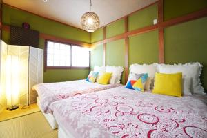 duas camas num quarto com paredes verdes em Sakurajima Parkside House B em Osaka