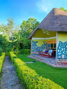 uma casa com telhado de palha e jardim em Paradise Eco-Hub em Kabale