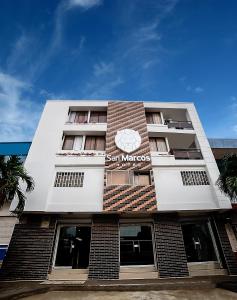 un edificio blanco alto con un letrero. en Hotel San Marcos Barranquilla, en Barranquilla