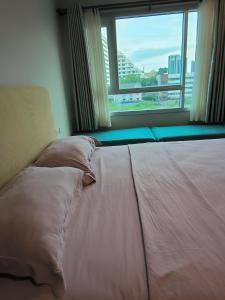 a bed in a room with a large window at centric sea Pattaya in Pattaya Central