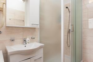 Un baño blanco con lavabo y ducha. en Villa Anka 2, en Cavtat 116 fotos más