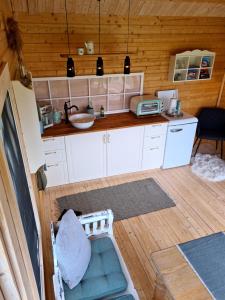uma cozinha com armários brancos e um balcão em Little, nice cottage for 2 with beautiful view em Lokken