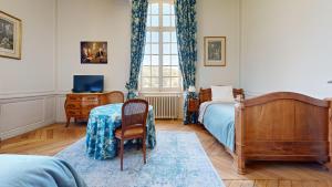 1 dormitorio con cama, mesa y ventana en La Templerie - Chambres d'hôtes, en La Flèche