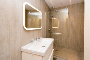 uma casa de banho com um lavatório branco e um chuveiro em Rosa Bonheur by Cocoonr em Toulouse