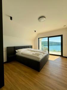 sypialnia z łóżkiem i dużym oknem w obiekcie Vila Valkov w mieście Bžany