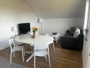 a living room with a white table and a couch at Apartament Osiedle Zielone in Chmielno