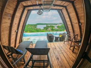 a room with a large window on a wooden deck at Sundown Lake Hotel & Spa in Habarana