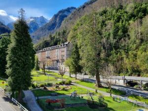 a park in front of a building in the mountains at Le Nid Ossalois in Eaux-Bonnes