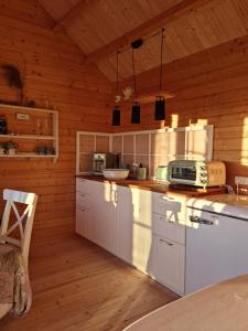 uma cozinha com electrodomésticos brancos e um tecto de madeira em Little, nice cottage for 2 with beautiful view em Lokken