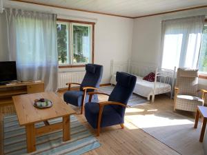 a living room with blue chairs and a table at Villa Siikakoski in Konnevesi