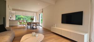 a living room with a couch and a tv on a wall at Villa Tibur - Near Boom & Rumst in Rumst +16 photos