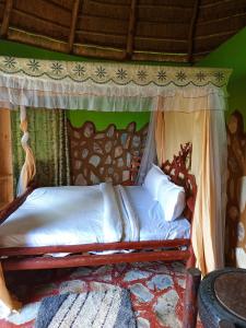 Paradise Eco-Hub في Kabale: سرير في غرفة بها مظلة