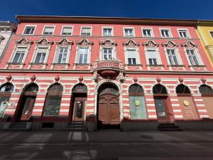 a large red brick building with a wooden door at Schreyer Apartman in Nagykanizsa