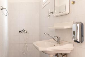 y baño blanco con lavabo y ducha. en Sifnos studio 5 en Sifnos