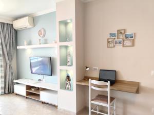 een kamer met een computer en een bureau met een monitor bij Lida's Seafront Apartments in Sarandë