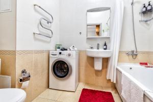 a bathroom with a washing machine and a sink at Красивые апартаменты на Экспо in Taldykolʼ