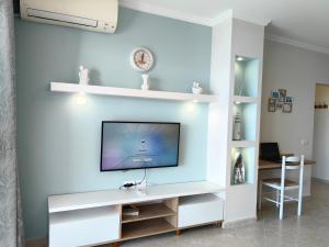 een woonkamer met een tv aan een witte muur bij Lida's Seafront Apartments in Sarandë