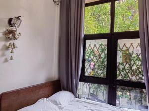 a bedroom with a bed and a window at Shanghai Garden Apartment - Near Downtown Wukang Road in Shanghai