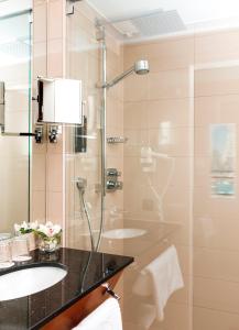 a bathroom with a glass shower and a sink at Hotel Am Parkring in Vienna