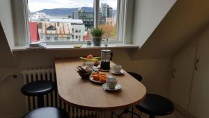 a table with a bowl of fruit on it in front of a window at Skólavörðustígur Apartments in Reykjavík