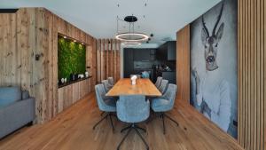 蒂羅爾州塞弗爾德的住宿－Triple A Chalets，一间带木桌和蓝色椅子的用餐室