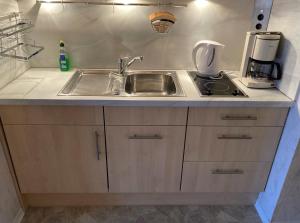 a kitchen counter with a sink and a coffee maker at Frische Brise FeWo 09 08 in Cuxhaven