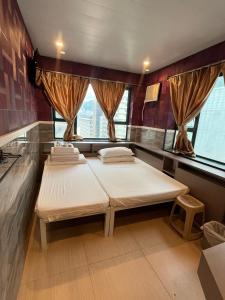 a room with two beds in it with windows at USA Hostel HONG KONG in Hong Kong