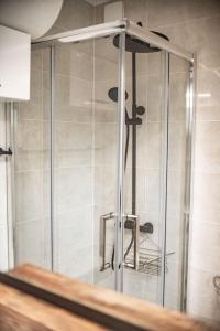 a shower with a glass door in a bathroom at Apartament ,szeregowy domek z tarasem i dwoma sypialniami , 800 metrów od plaży in Pobierowo +48 photos