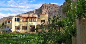 a large building with a mountain in the background at Trinity Home Stay in Leh