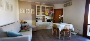 a room with a table with chairs and a kitchen at SunDays House #casa al mare in Quartu SantʼElena