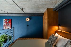 Una habitación con una cama y una pared azul. en Paupys lofts, en Vilna