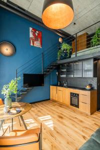 sala de estar con mesa y pared azul en Paupys lofts, en Vilna