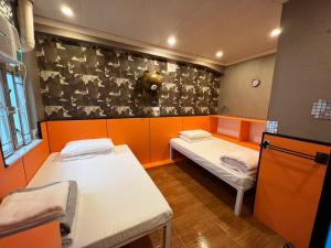 a small room with two beds and a wall with at USA Hostel HONG KONG in Hong Kong